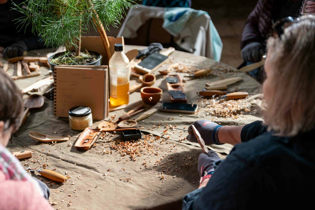 Woodworkers carving at a table in a workshop