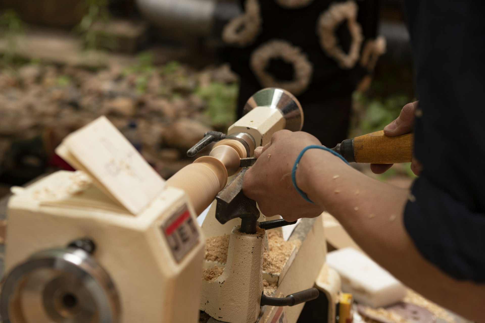 A woodworker shaping wood on a lathe in a workshop